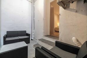 A small outdoor seating area with wicker furniture, a tiled floor, and a white wall. - Magnificent apartment - AC- 2BR- 4P - Cannes (Cannes)