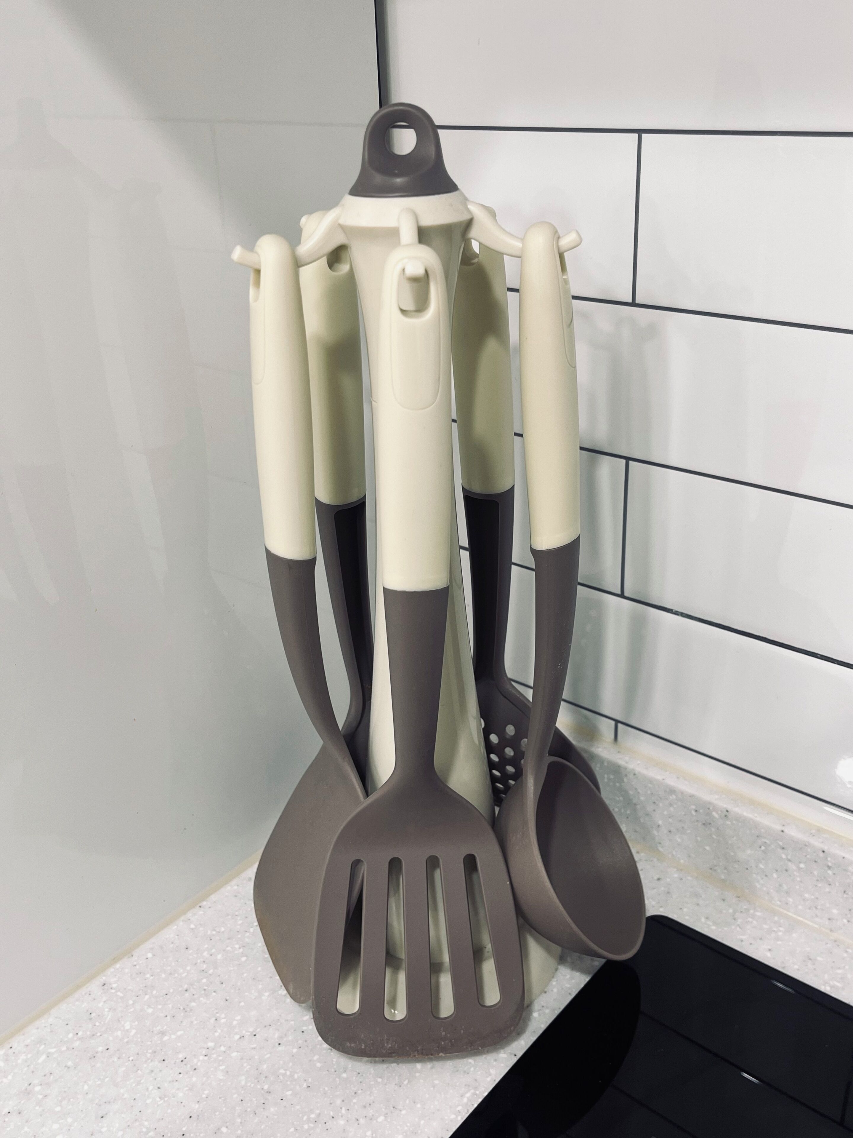 Un recipiente para utensilios de cocina con varias espátulas y una cuchara para servir.