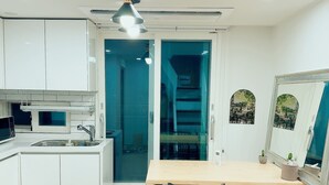 Una cocina moderna con armarios blancos, una mesa de comedor de madera y sillas negras.