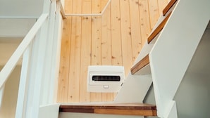 Una escalera de madera con un pequeño ventanal en la parte superior.