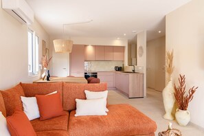 Ein modernes Wohnzimmer mit Sofa, Essbereich und Küche.