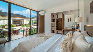 A modern bedroom with a large bed, a desk, and a view of a pool and outdoor area. - Villa Anarya Ubud (Ubud)