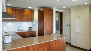 Una cocina moderna con armarios de madera, una isla grande, un tostador y un refrigerador.