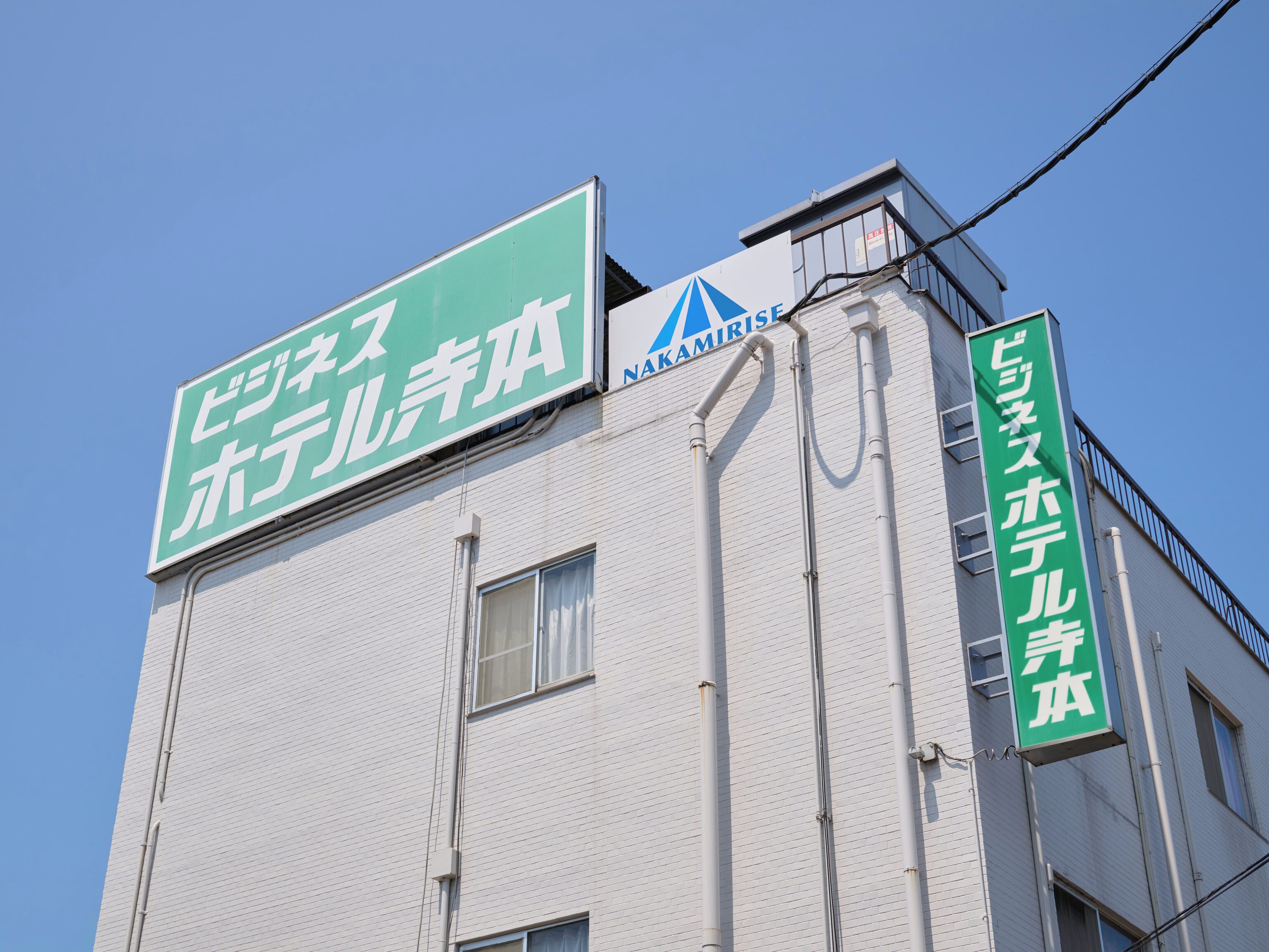 A building with a sign that reads "Nakamitsu Hotel" and another sign indicating "Nakamitsu Hotel" in English.