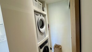 A laundry room with two stacked washing machines, a drying rack, and a storage basket. - L'OUSTAU DE FLAYOSC (Flayosc)