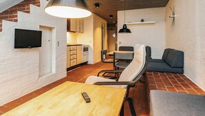 Un espace de vie compact comprenant une cuisine, un coin repas et un espace détente.