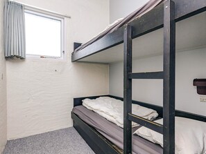 A bunk bed room with a window, a wall socket, and a carpeted floor. - 6 Person Holiday Home in Brovst (Brovst)