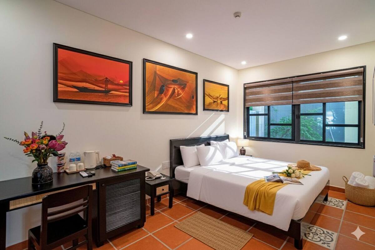 Una habitación de hotel con cama, escritorio y una obra de arte en la pared.