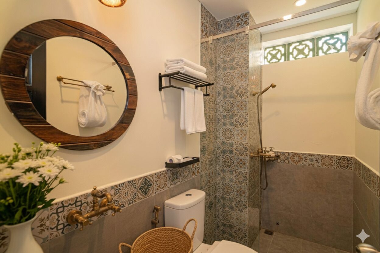 Un baño con un espejo redondo, un inodoro, una ducha y un lavamanos.