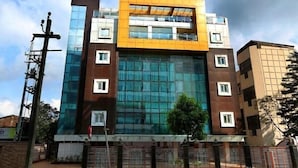 Un bâtiment moderne doté d’une façade en verre, de nombreuses fenêtres et d’un toit plat.