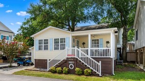 A single-story house with a front porch, a small staircase, and a mailbox.