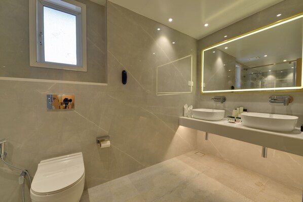 A modern bathroom with a toilet, two sinks, a large mirror, and a window. - The Fern Residency Mumbai, Mira Road, Series by Marriott (Mumbai)