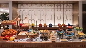 Montaje de bufé con diversos alimentos y un fondo decorativo.