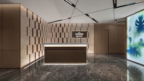A modern lobby with a reception desk, a patterned wall, and a digital screen displaying 'FOOD EXCHANGE'. - Novotel Kunshan East (Suzhou)