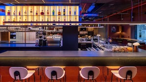 Eine moderne Bar mit einer Neonreklame, einer Auswahl an Flaschen und einer Bar.