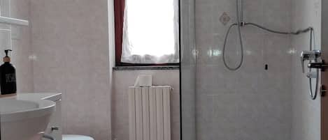 Un baño con ducha, inodoro y lavamanos.