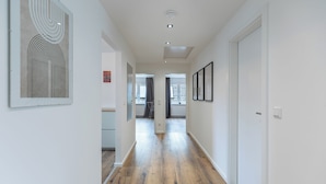 A hallway with wooden flooring, white walls, and framed artwork. - Vacation apartment "Heimathafen" in Breklum for up to 4 people (Breklum)