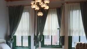 Habitación de hotel con dos camas, una mesita, una silla y una araña.