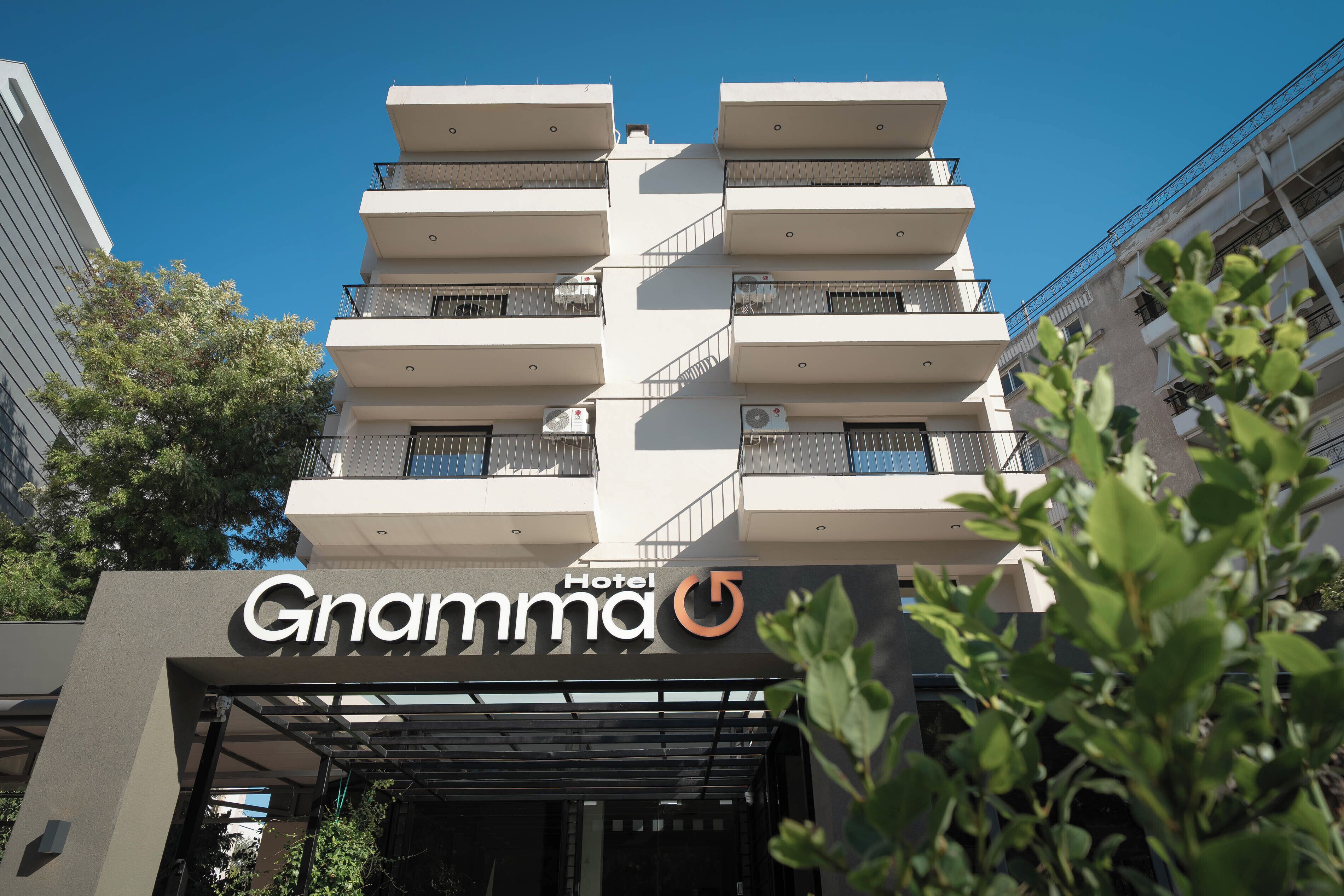 A multi-story hotel building with balconies and air conditioning units.