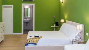 A hotel room with a bed, bedside table, lamp, and a mirror.