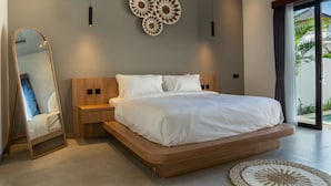 A modern bedroom with a wooden bed, a large mirror, and decorative wall art. - The Moringa Bukit Villas (Kutuh)