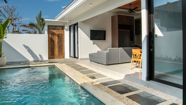 A modern house with a swimming pool, a wooden door, and a grey sofa. - The Moringa Bukit Villas (Kutuh)