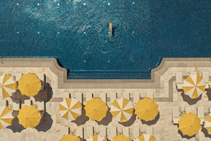 Una piscina al aire libre, sombrillas, tumbonas