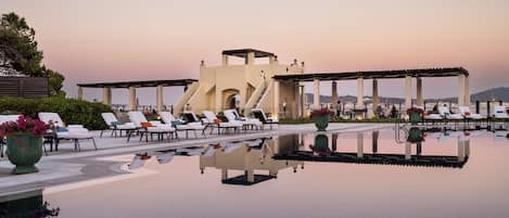 Alberca al aire libre, sombrillas en la alberca y camastros