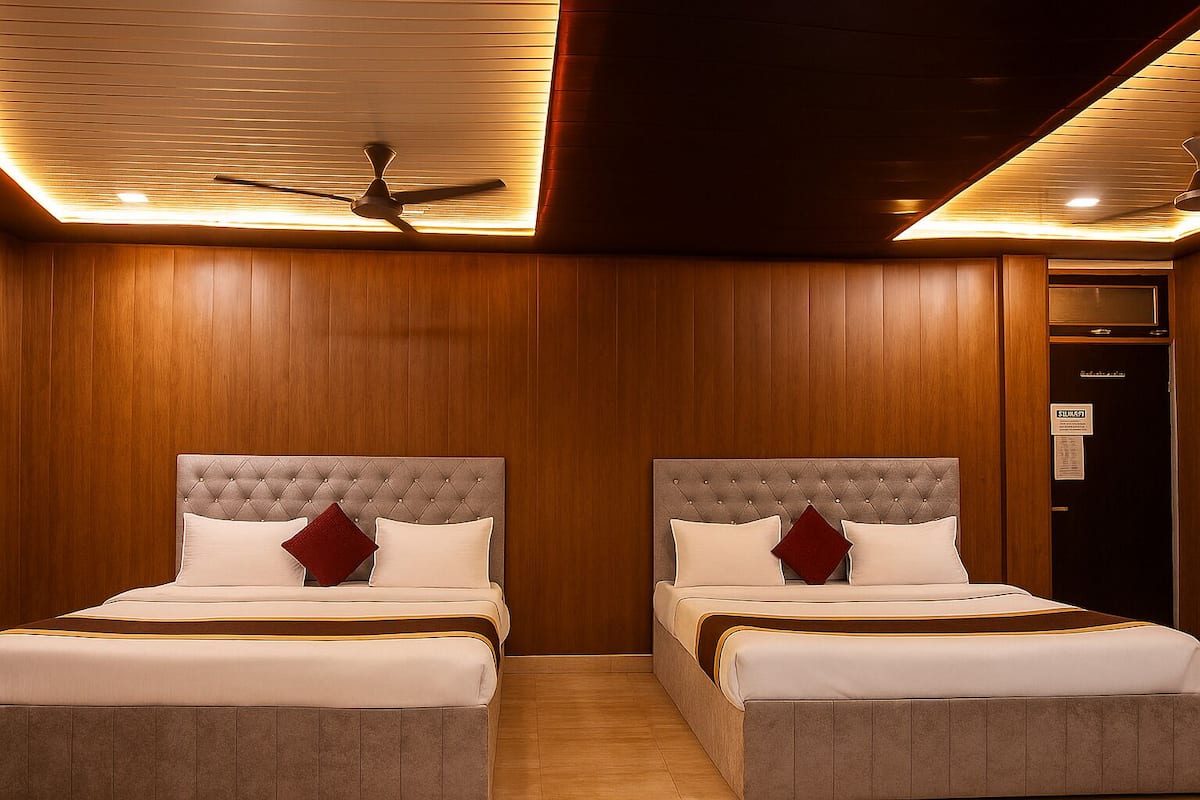 A hotel room with two beds, wooden paneling, a ceiling fan, and a door with a sign.