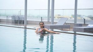 A pool area with lounge chairs and a view of the cityscape. - Siddharth The Fern An Ecotel Hotel Jalna (Jalna)