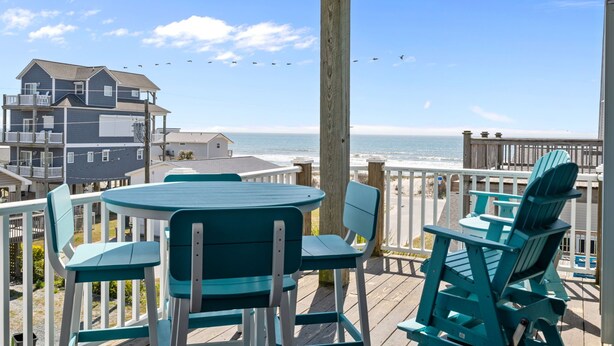 A deck with chairs and a table overlooking the ocean. - Steps to Beach Access, 4 Bedrooms w/ King Suite, Fenced Yard, Pup Friendly (North Topsail Beach)