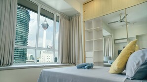 Une chambre d’hôtel avec un lit, une grande fenêtre, une armoire et une vue sur une tour.