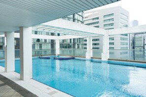 Una piscina interior amb parets de vidre transparent, un paviment de rajoles i un disseny arquitectònic modern.