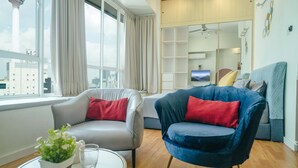 Un salon moderne avec un canapé, un fauteuil et une petite table sur laquelle est posée une plante.