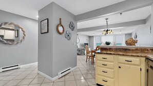 A modern kitchen with a central island, grey walls, and decorative wall art.