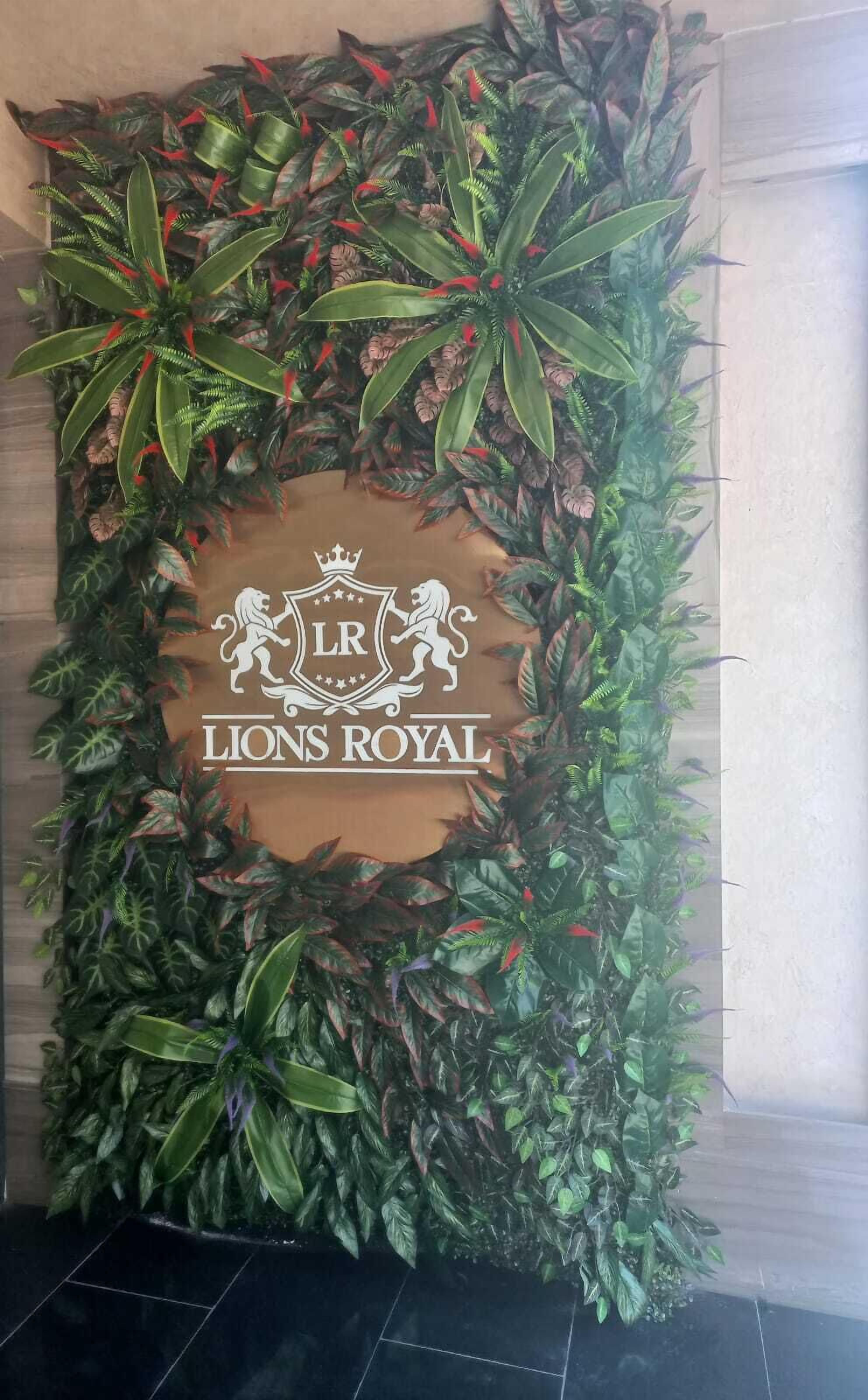 A decorative wall with a logo and text reading "Lions Royal".