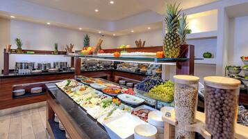 A buffet with various food items and a wooden counter.
