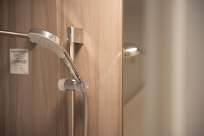 A showerhead with a control panel, a wooden door, and a metallic handle.