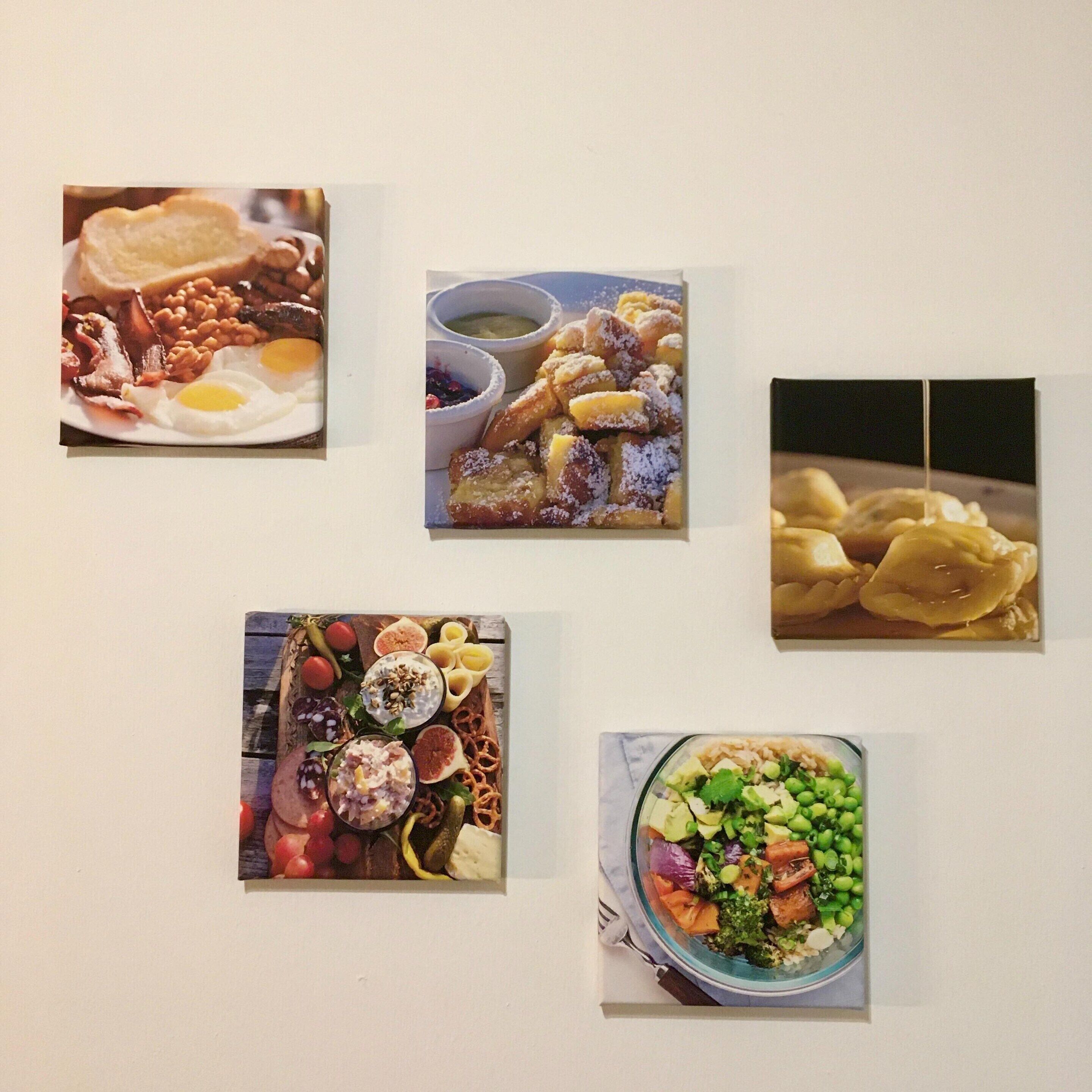 Una pared con cuatro cuadros que muestran diferentes platos.