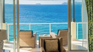A balcony with wicker furniture and a view of the ocean.