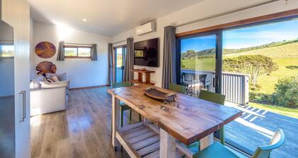 Harvest Cottage Onetangi - Peaceful 2-bedroom cottage with vineyard views and a paddock of grazing horses. 10-min walk to Onetangi Beach, close to top wineries and cafés. Two queen bedrooms, full kitchen, smart TV, heat pump, and sunny deck. Includes