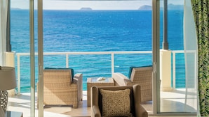 A balcony with wicker furniture and a view of the ocean.
