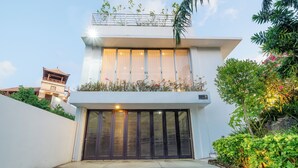 Una casa moderna de dos pisos con balcón, ventanas amplias y garaje.