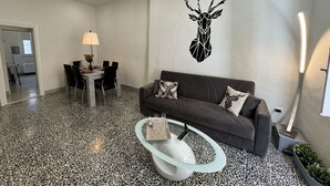 A modern living room with a sofa, coffee table, and dining area. - Nice apartment for 5 guests with WIFI, A/C and TV (Lucca)