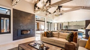 A spacious living area with a modern fireplace, a large sofa set, and a dining area.