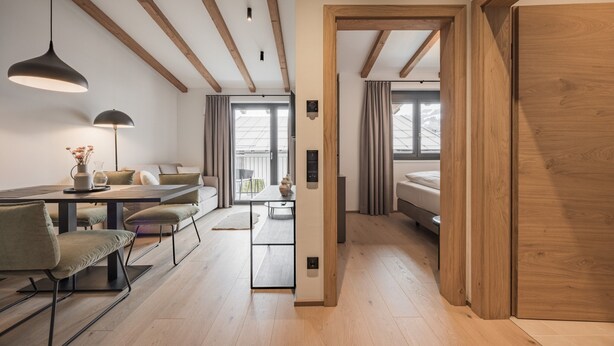 Ein modernes Interieur mit Essbereich, einer Couch und Holzböden.