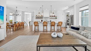 A spacious living area with a wooden coffee table, a sofa, and a dining area with wicker chairs.