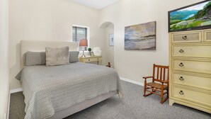 Un dormitorio con cama, cómoda, silla, ventana y un cuadro en la pared.