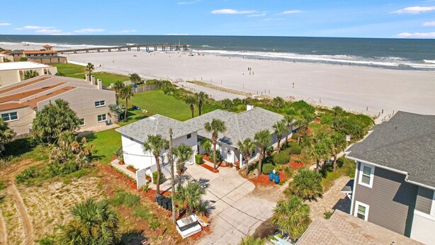 Zona residencial costera con casas, una playa y un muelle.