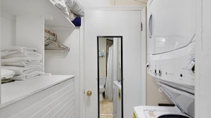 A laundry room with stacked towels, a washing machine, and a dryer.